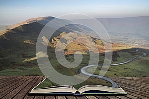 A scenic road winds its way through the Edale Valley on a foggy Winter sunrise in the Peak District in pages of open book, story