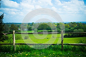 Scenic rural landscape featuring lush farmland and fence in Surr