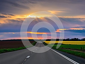 Scenic rural road stretching into the horizon, illuminated by a vibrant, picturesque sunset