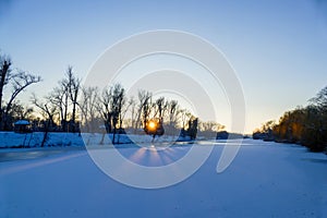 Scenic russian winter wonderland sunset view of non frozen river with trees scenery reflections on water panoramic wide