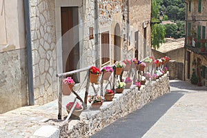 Scenic and rustic street with flowerpots in Valldemossa, Majorca