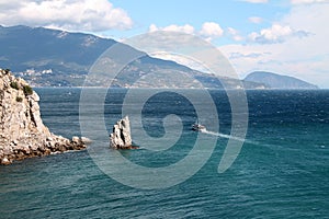 Scenic sea view with rocks and cliffs. Ship sails away.