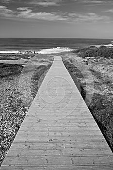 Scenic seascape empty wooden pathway leading to atlantic ocean with waves