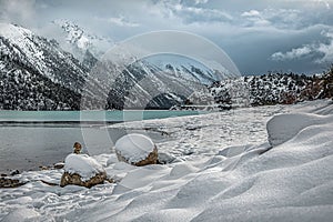 Scenic shot of the bank of the lake Ranwu in Tibet, covered with snow