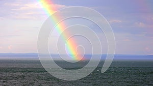 Scenic shot of a beautiful rainbow over the calm sea