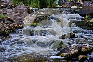 Scenic shot of the flow of a rocky river with a silky water effect