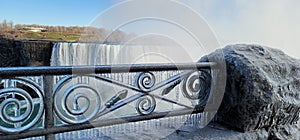 Scenic shot of an iced metal fence in front of the Niagara Falls in Canada in winter