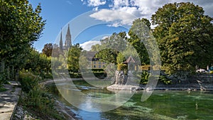 Scenic shot of a river and green trees with Konstanz Minster in the background. Germany.