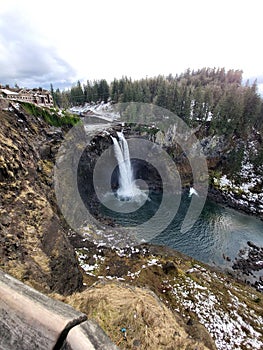 Scenic shot of Snoqualmie Falls surrounded by a winter forest