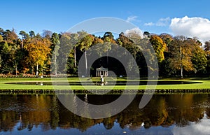 Scenic shot of the trees, grass fields, and a river near the Fountains Abbey in Ripon, UK