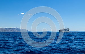 Scenic shot of the water surface of a sea in Croatia with an island and a ship on the background