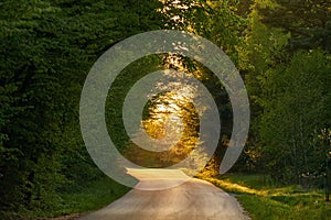 Scenic shot of a winding country road with a beautiful sunset in the background