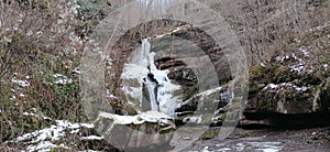 Scenic shot of the winter landscape with a waterfall and melting snow