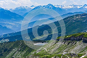 Scenic skyline of snowy mountain tops and green wooded mountainsides