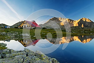 Scenic summer landscape shot in the mountain with hut reflection in a beautiful lake