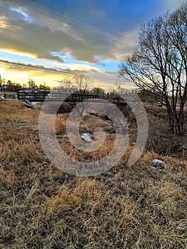 Scenic sunset on the horizon on a walking path with a bridge