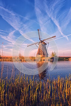 Scenic sunset landscape with windmill and sky, traditional dutch village of mills Kinderdijk, Netherlands