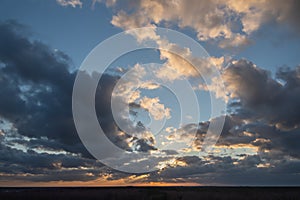 Sunset over the forest with sun rays breaking through clouds