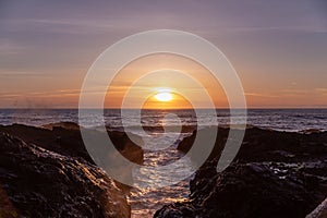 Scenic sunset over Pacific ocean. Sun reflection on the water inside a chasm at Cape Perpetua