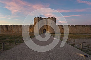 Scenic sunset view of the ancient city wall of the Aigues-Mortes. Entrance to the Old Town