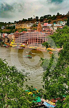 Scenic tourist boats on Narmada river against the backdrop of omkareshwar Temple.