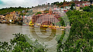 Scenic tourist boats on Narmada river against the backdrop of omkareshwar Temple.