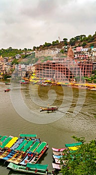 Scenic tourist boats on Narmada river against the backdrop of omkareshwar Temple.