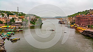 Scenic tourist boats on Narmada river against the backdrop of omkareshwar Temple.