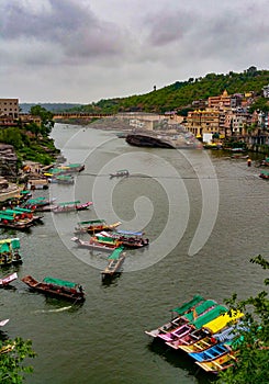 Scenic tourist boats on Narmada river against the backdrop of omkareshwar Temple.