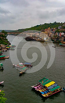 Scenic tourist boats on Narmada river against the backdrop of omkareshwar Temple.