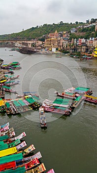 Scenic tourist boats on Narmada river against the backdrop of omkareshwar Temple.