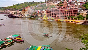 Scenic tourist boats on Narmada river against the backdrop of omkareshwar Temple.