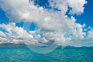 Scenic of the tropical island, sea ocean water, mountain on horizon and cloudy sky