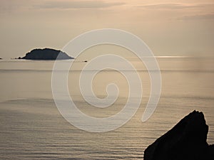 Scenic twilight view of calm waveless seawater with rock formations