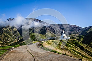 Scenic view on abandoned buddhist temple, mountains and road to mountain Aso