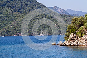 Scenic view of the Aegean Islands. The unique shades of the sea and the rocks covered with pine trees