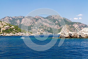 Scenic view of the Aegean Islands. The unique shades of the sea and the rocks covered with pine trees