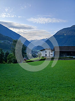 Scenic view of the Austrian village of Wolfurt against the backdrop of the Alps and green meadows. Vertical. Wolfurt, Austria