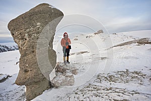 Scenic view of the Babele rocks in the Bucegi mounatins during winter with a young gril climber. photo