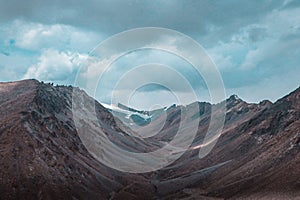 Scenic view of barren mountains under a cloudy sky