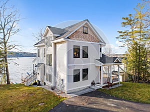 Scenic view of a beautiful white modern house near the lake on a sunny day