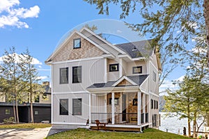 Scenic view of a beautiful white modern house near the lake on a sunny day