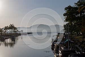 Scenic view of boats moored on the calm coast on a misty morning