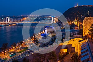 Scenic view of Budapest city at blue hour with illuminated Buda Castle, Citadella on Hellert Hill and Danube embankment
