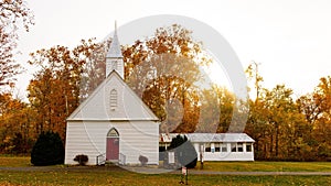 Scenic view of a church on green hills on a cloudy day in autumn