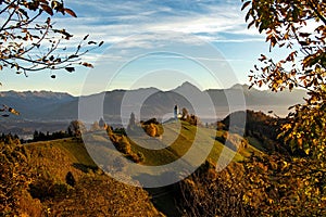 Scenic view of The Church of St. Primoz and Felicijan on an evergreen hill in Jamnik, Slovenia