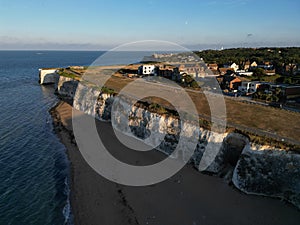 Scenic view of a cliff jutting out over the water with a beach and houses. Broadstairs, UK.