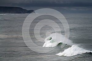 Scenic view of the coastline along the Amado Beach Praia do Amado with big waves during a storm, in Algarve