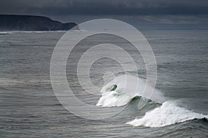Scenic view of the coastline along the Amado Beach Praia do Amado with big waves during a storm, in Algarve photo