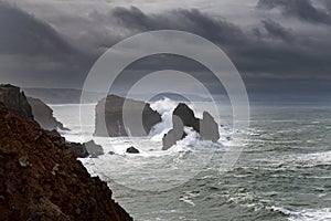 Scenic view of the coastline along Carrapateira with the rock formations and waves crashing in the rocks during a storm